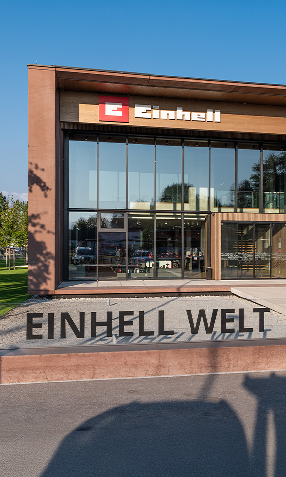Einhell World: อาคารบริษัททันสมัยพร้อมโลโก้ Einhell และพนักงานกลุ่มใหญ่