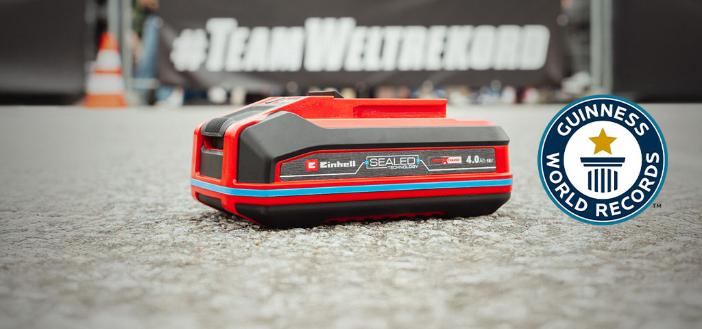แบตเตอรี่ Einhell SEALED Power X-Change 4.0 Ah วางอยู่บนพื้น โดยมีโลโก้ Guinness World Records "Record Holder" อยู่ทางขวา